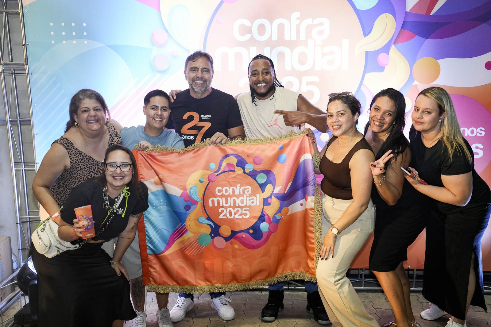 Equipe reunida segurando a bandeira da Confra Mundial 2025