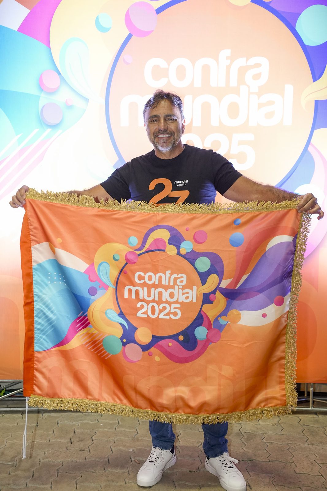 Diretor segurando a bandeira da Confra Mundial 2025